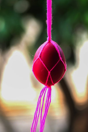Easter eggs in handmade pink cotton knitted bags on nature background.の写真素材
