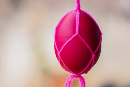 Easter eggs in handmade pink cotton knitted bags on nature background.の写真素材
