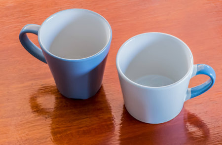 Two cups of empty for coffee art on wooden background. light blue  and white ceramic cups, stylish toning, place for text.の写真素材