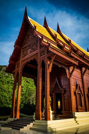 Ubosot from teak thai style near the mountainの写真素材