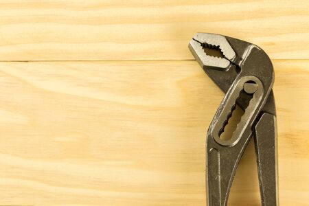 Pair of steel mole grips with adjustable jaws on wood table