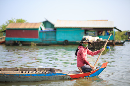 TONLE SAP LAKE SIEM REAP, CAMBODIA - JANUARY 10: unidentified girl paddle from front part of a boat on January 10, 2012 at Tonle Sap Lake, Siem Reap Cambodiaのeditorial素材