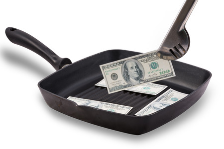 Dollar bills in grill coating pan isolated on whiteの写真素材