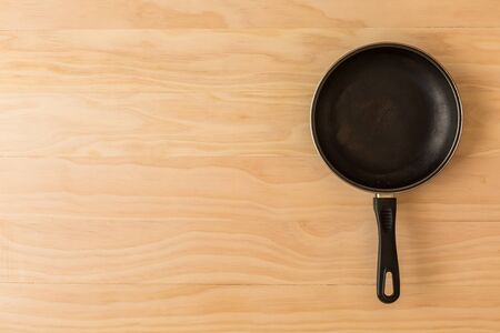 non stick frying pan on wooden backgroundの写真素材