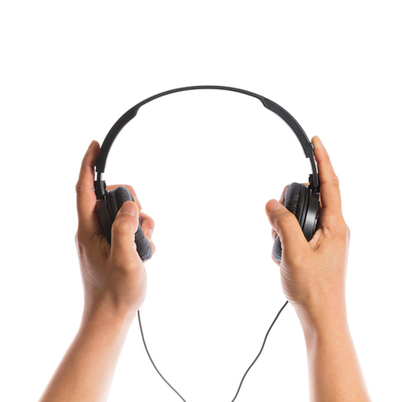 hands holding headphones isolated on white backgroundの写真素材