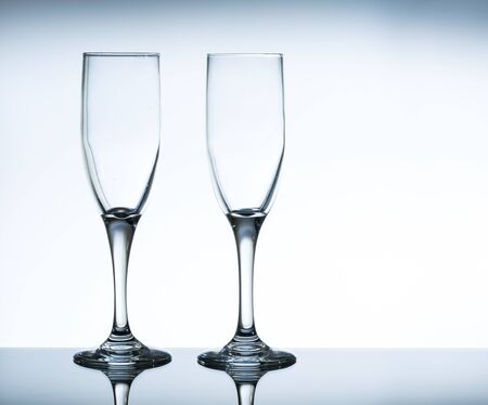 empty champagne glass on the glass table and white backgroundの写真素材