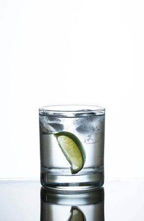 slice of lime in glass of water and iceの写真素材