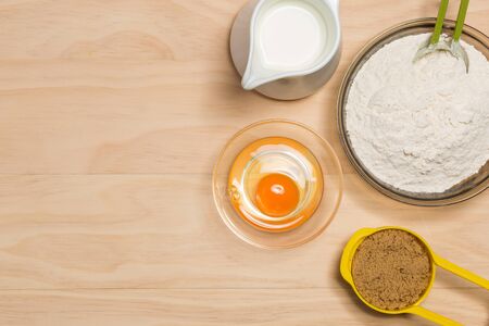 flour, egg, milk and sugar on wooden backgroundの写真素材