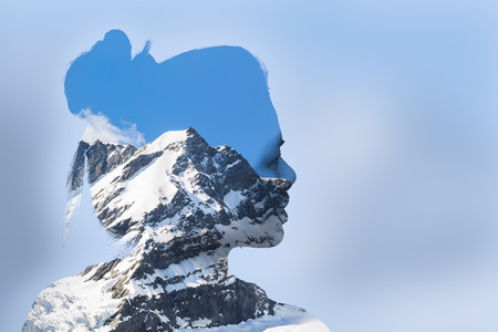 Double exposure portrait of young woman and mountain cover with snowの写真素材