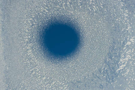 frozen glass with thawed hole background