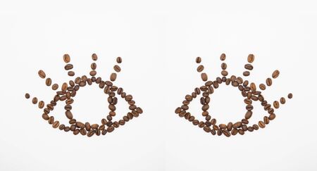 Arranged coffee beans to be opening eyes shape on white backgroundの写真素材