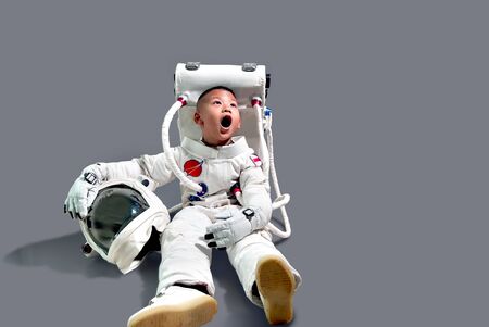 Little boy in space suit. Astronaut boy sitting. Kid in space suit.The kids' dream jobs.Cute little...