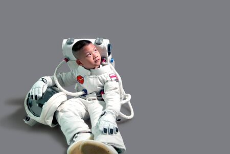 Little boy in space suit.Astronaut boy sitting.  Kid in space suit.The kids' dream jobs.Cute little...