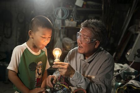 Cute boy learning with his grandfather.It is interesting to learn.の写真素材