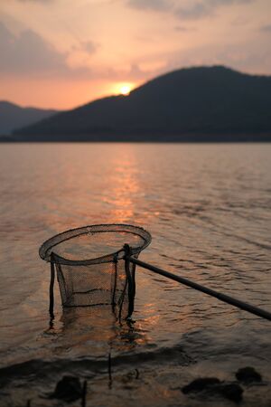 Fish scoop and evening sunsetの写真素材