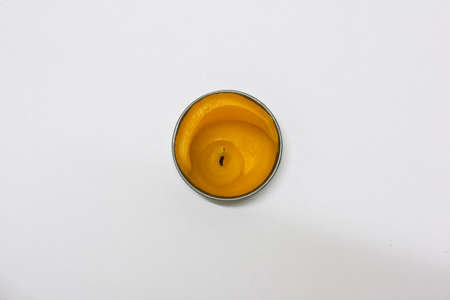 Yellow candle is placed in a circular white background