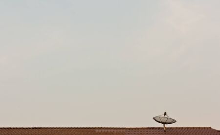 Satellite dish on the roof of red tilesの写真素材
