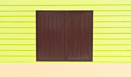 Window is made of brown wood on a green wallの写真素材