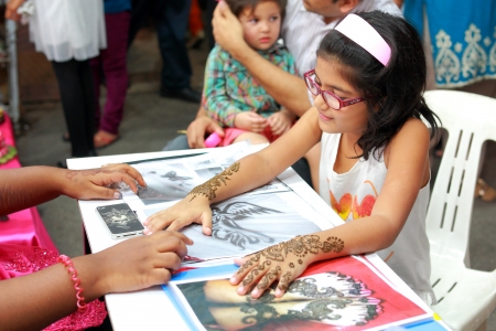 Painting henna on the back of the hand of a young lady in a bazaarのeditorial素材
