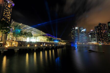 The public enjoying the light show at MBS with the city nights cape as the back drop  The light show named Wonder full lasted for 13mins  This is the free showcase of stunning visual effects with interweaving lasers, video projectors and giant streaming wのeditorial素材