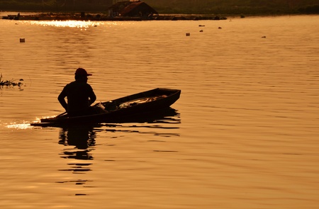 Silhouette of a man rowing in the canoe.