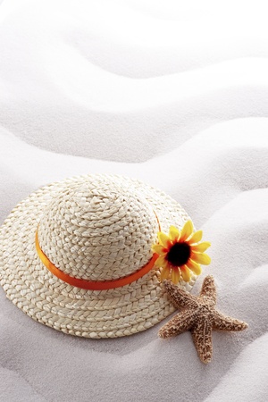 starfish and straw hat on white wave sandの写真素材