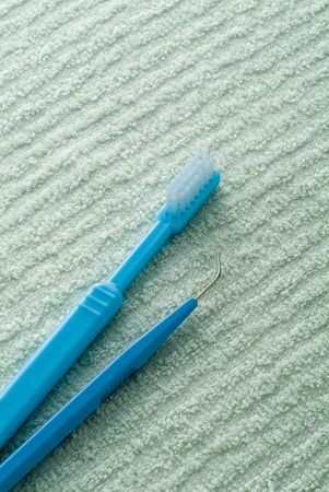 Toothbrush and cleaner between tooth on green towel.の写真素材