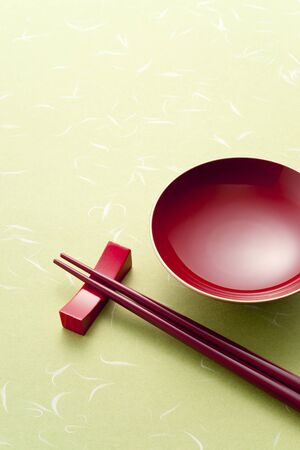 red sake cup and chopsticks on green backgroundの写真素材