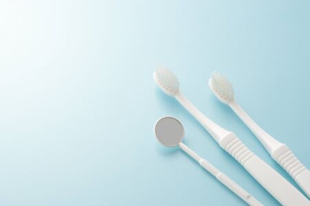 toothbrush and small mirror on blue backgroundの写真素材