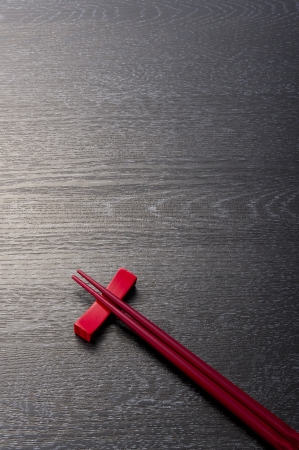 red chopsticks on wooden blackの写真素材