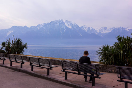 A man sitting on the bench by the lake in Switzerlandの写真素材