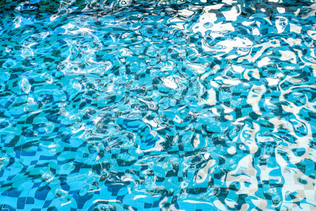 Swimming pool with sun reflections. Blue swimming pool water background.の写真素材