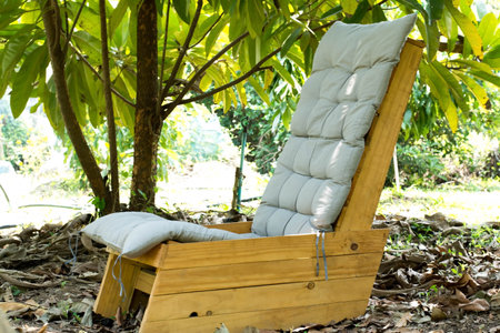 Chaise lounge in the garden with natural green background, Thailand.