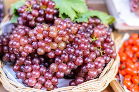 Fresh grapes in a basket on the counter of a farmers market.の写真素材