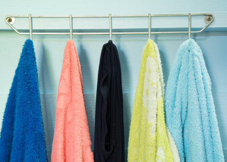 Colorful towels on hangers in the bathroom. Toned.の写真素材