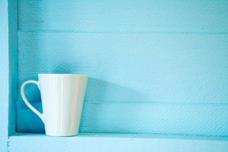 White coffee cup on blue wooden shelf - Vintage filter processing style picturesの写真素材