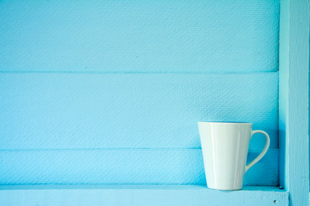 Coffee cup on blue wooden wall - vintage effect style picturesの写真素材