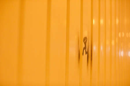 A closeup shot of a man's shadow on a yellow wallの写真素材