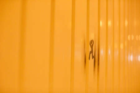 running figure on yellow background in the streetの写真素材