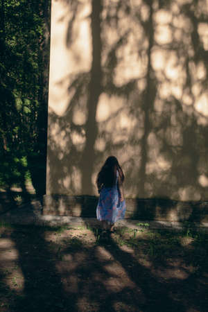 Shadow girl on an orange wall in summer