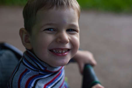 Portrait of little boy posing outside in parkの写真素材