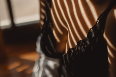 beautiful female breasts in luxury bra with shadow at sunlight closeup imageの写真素材