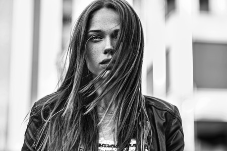 Street fashion concept. Young beautiful model in the city. Beautiful blonde woman close-up portrait of a young girl hipsterの写真素材