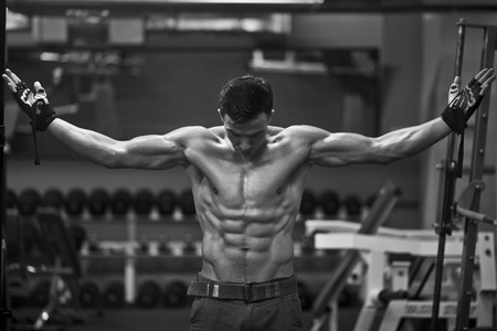 Athlete muscular brutal bodybuilder emotional posing in the gymの写真素材