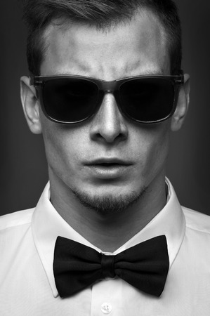Portrait of men with sunglasses in white tuxedo and bow tieの写真素材