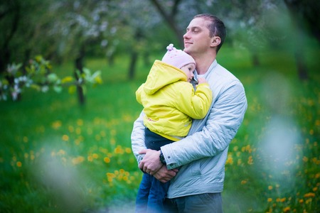 Dad and his daughter are playing in the beautiful spring parkの写真素材