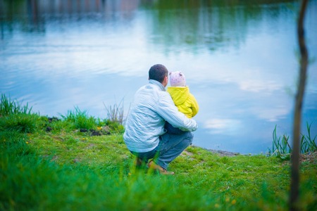 Dad and his daughter are playing in the beautiful spring parkの写真素材