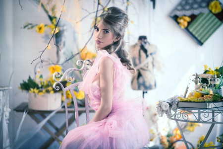 Girl in a gently pink dress in an interior studioの写真素材