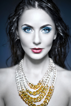 Beautiful woman with jewelry and beauty blue make up.の写真素材