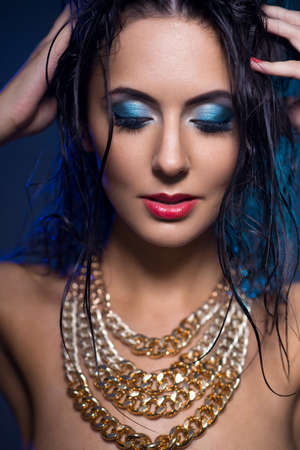 Beautiful woman with jewelry and beauty blue make up.の写真素材